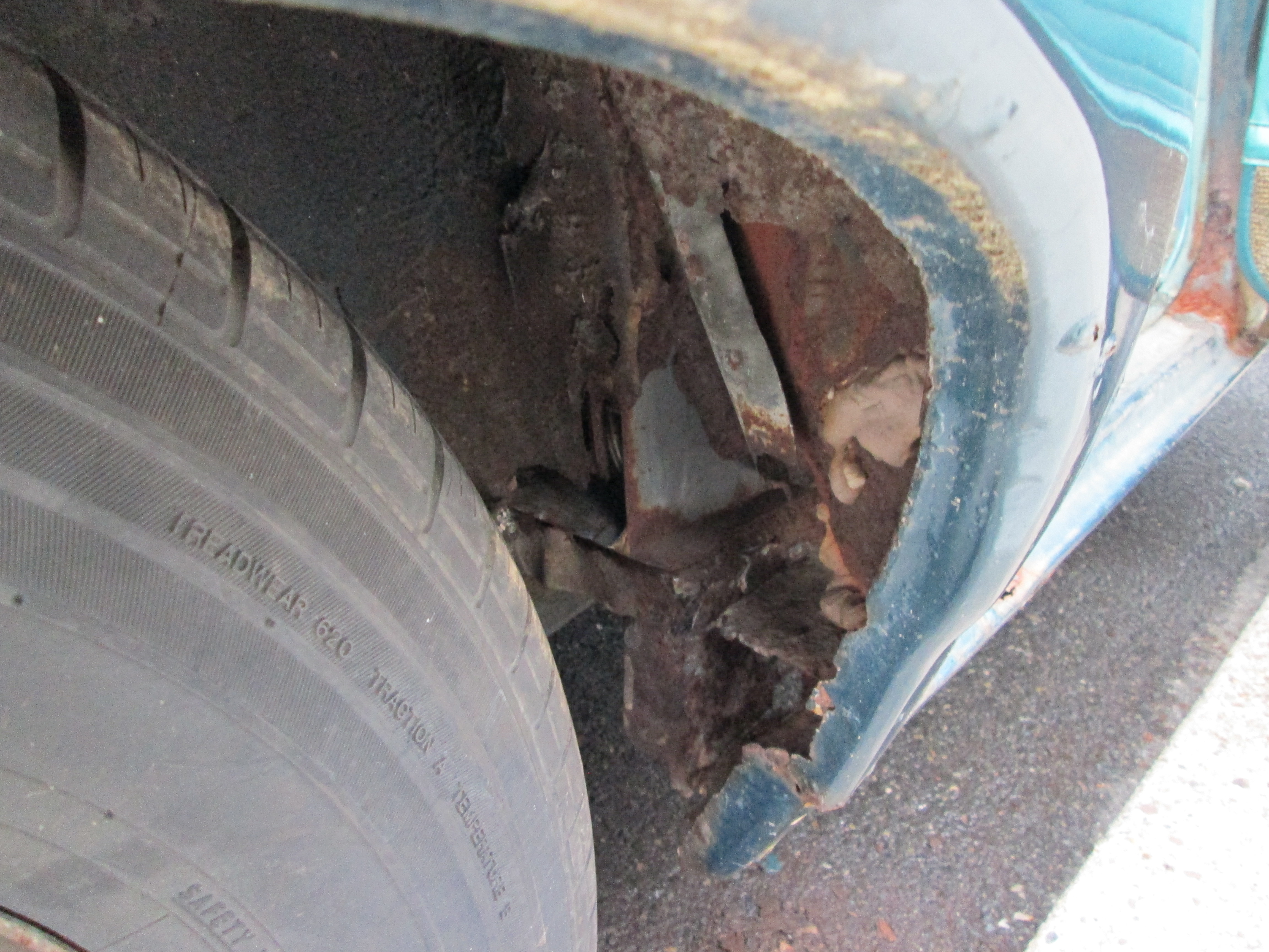 Rear right wheel well was patched up with that bondo slab. Hole was probably created by years of road salt damage